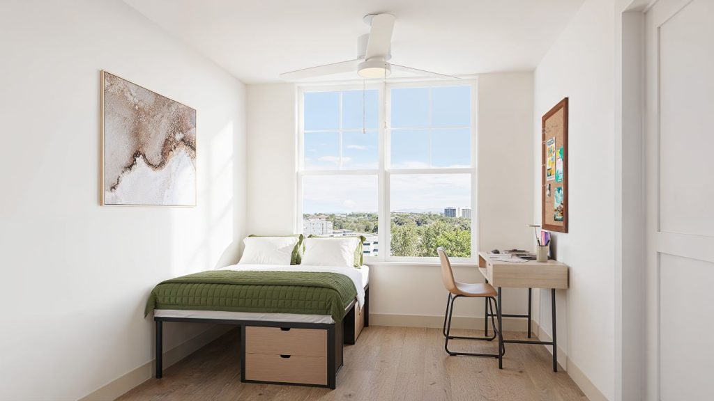 Furnished bedroom rendering in a modern Brickside apartment, featuring a bed, desk, chair, and window with natural light.