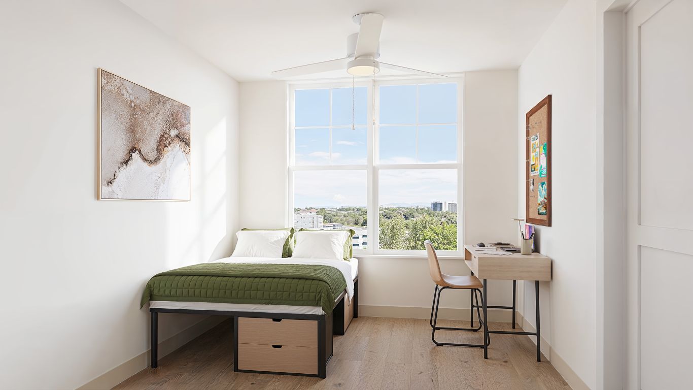 Furnished bedroom rendering in a modern Brickside apartment, featuring a bed, desk, chair, and window with natural light.