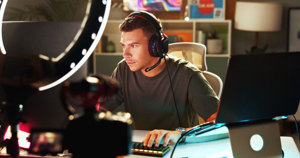 Young male student in his apartment gaming with a high-tech setup